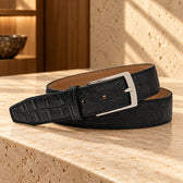 Curea din piele naturală Croco Black, de culoare neagră. Cadru din unghi, pe o suprafață de piatră.