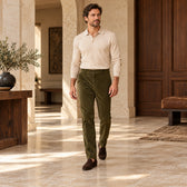 Pantaloni raiați olive, purtați cu un polo bej și mocasini maro Cadru integral în mers.